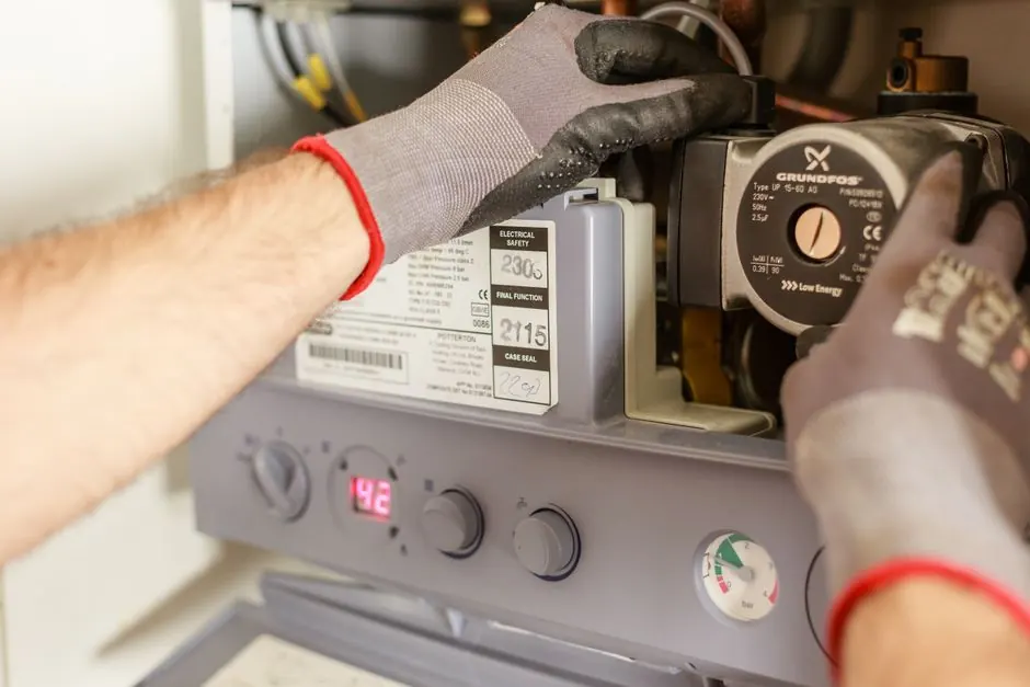 Technician inspecting a residential boiler heating system